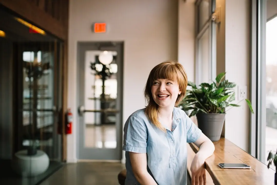 A person sitting at a cafe window, smiling