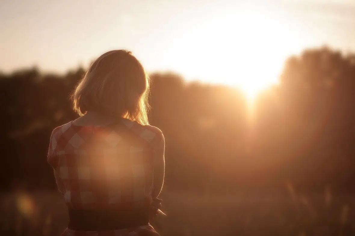 The silhouette of a person facing a sunset