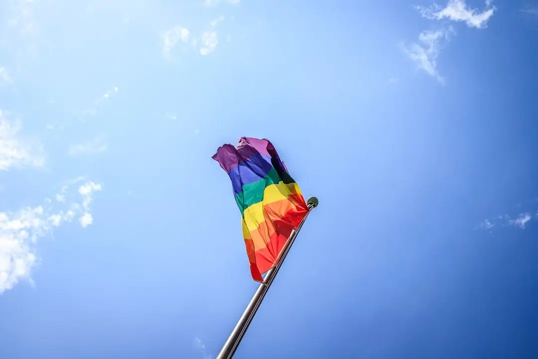 A rainbow Pride flag against a clear blue sky
