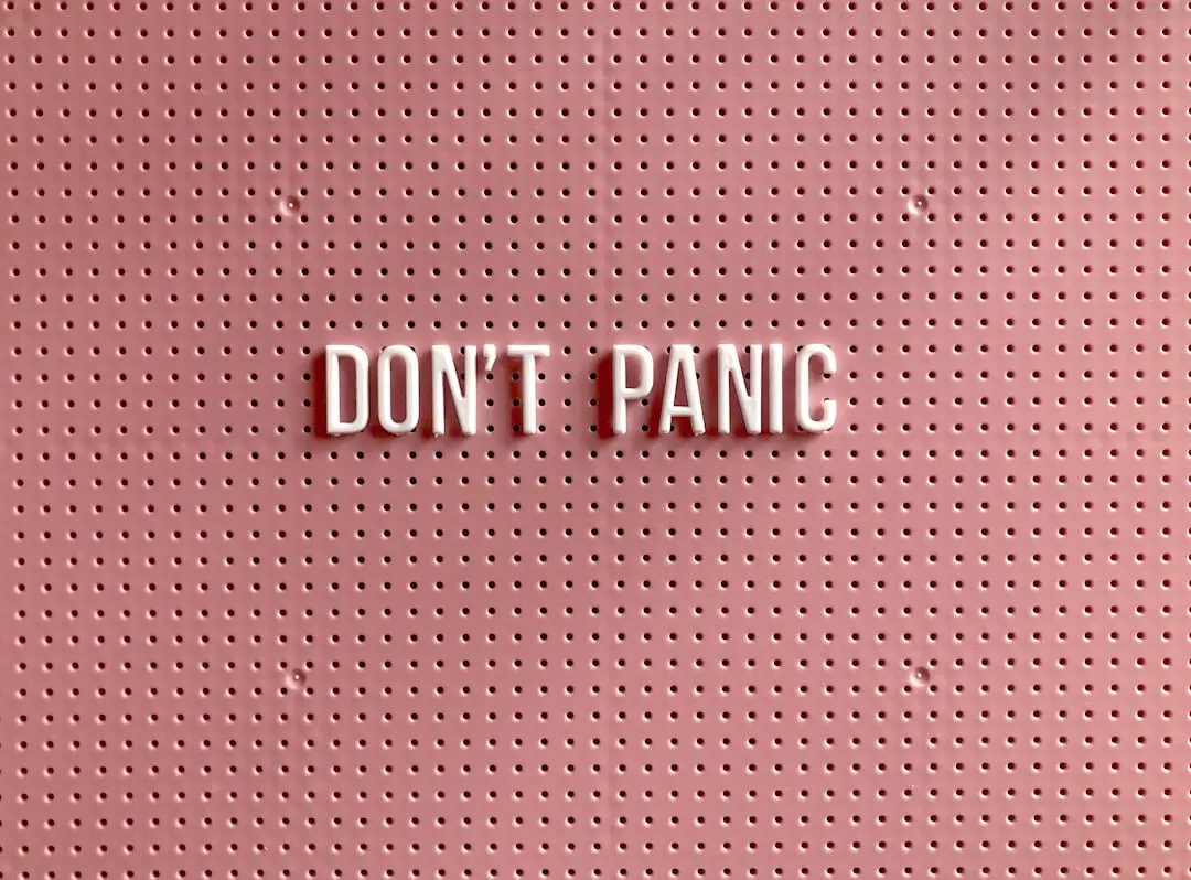 A sign on a pink pegboard reading Don't Panic