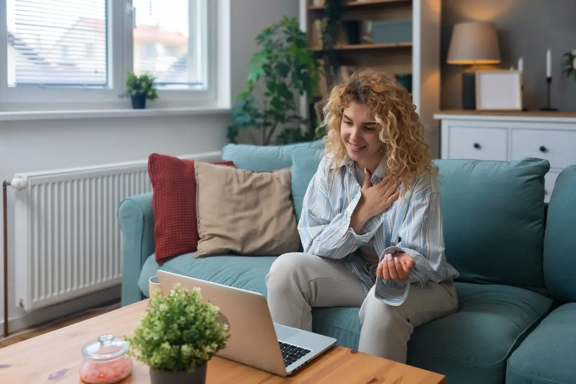 A person on a video appointment from a sofa