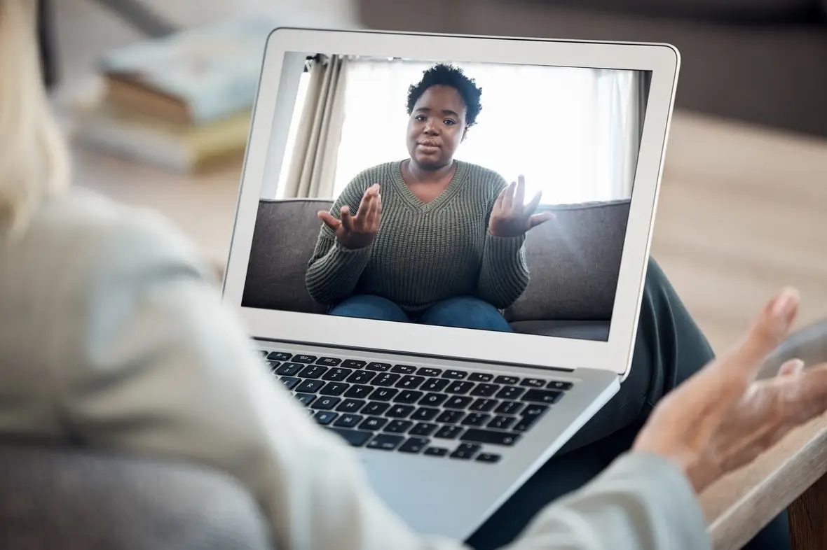 An over-the-shoulder view of a video appointment with a clinician