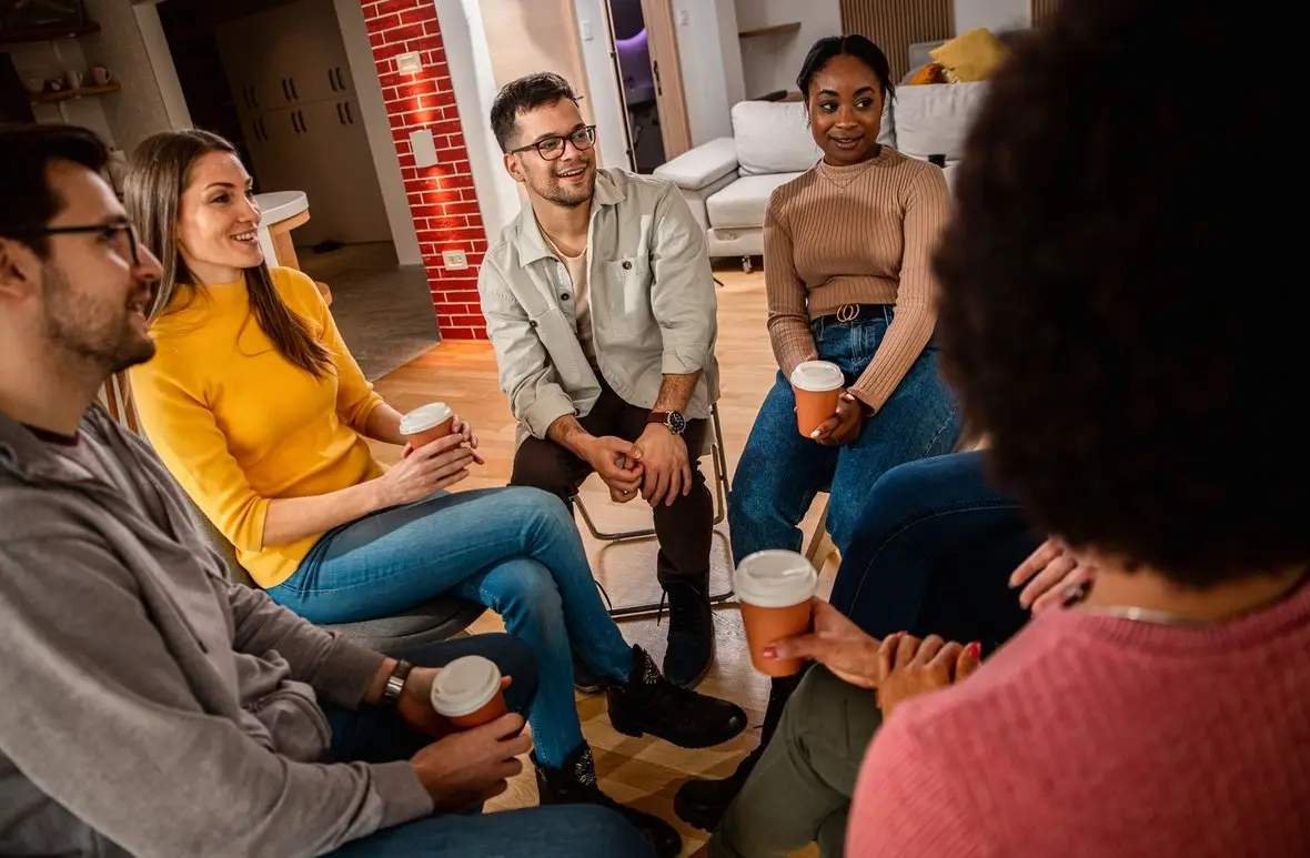 A group of people with drinks sitting in a circle