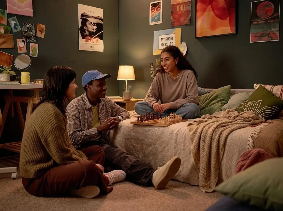 Friends sitting together in a bedroom, talking