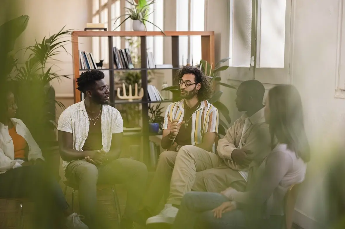 A group of people talking in a bright room