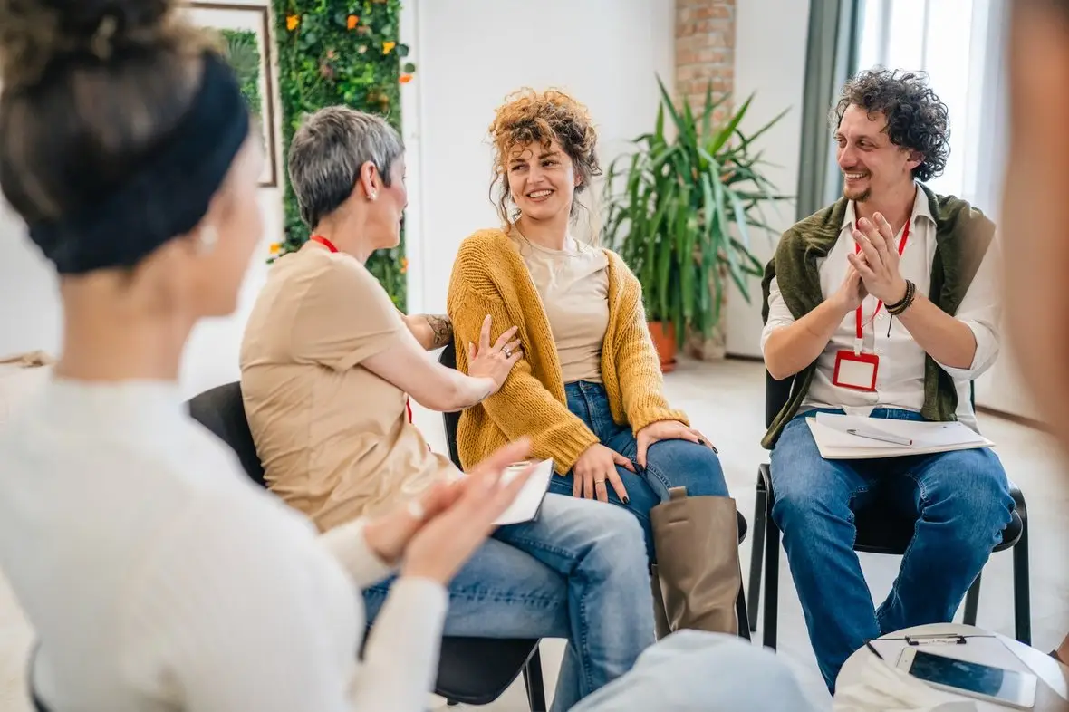 A group session with people talking and reaching out to one another
