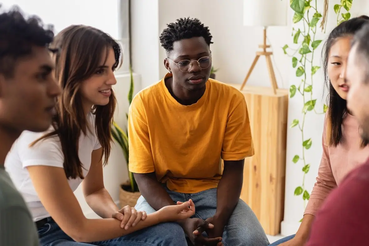 A group of people talking together in a bright room