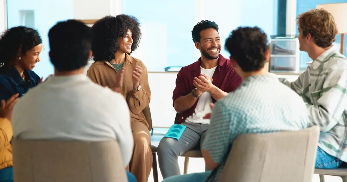 A group of people applauding in a circle