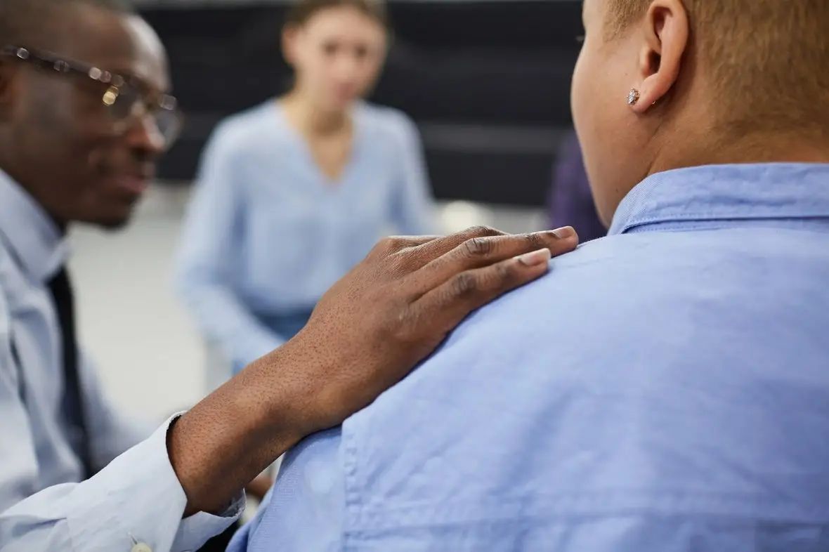 A clinician resting a hand on a person's shoulder