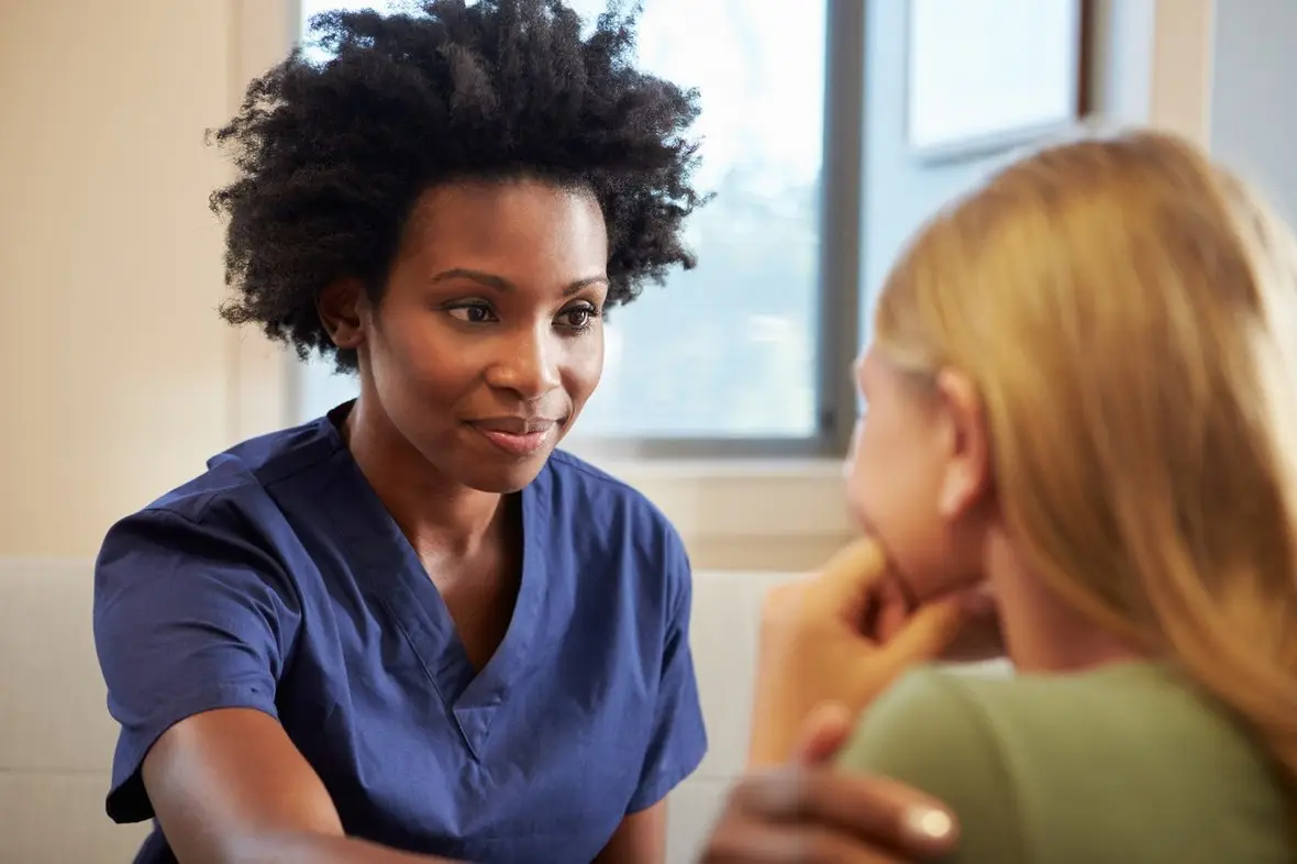 A nurse practitioner talking with a client